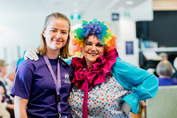 Youth volunteer with member of Elks Clown Band